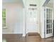 Inviting foyer featuring hardwood floors, a charming front door, and a view into another room through glass doors at 10732 Trolley Run Dr, Cornelius, NC 28031