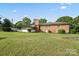 Spacious backyard with lush green lawn, brick house, and a screened-in porch at 1155 Melrose Dr, Rock Hill, SC 29732