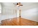 Bright bedroom featuring hardwood floors, a ceiling fan, and convenient closet space at 1155 Melrose Dr, Rock Hill, SC 29732