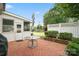 Cozy patio features brick pavers, white picket fence, trimmed hedges, and table under closed gray umbrella at 1155 Melrose Dr, Rock Hill, SC 29732
