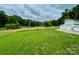 Lush green backyard with a wooden fence, utility pole, and a detached garage at 117 Autumn Woods Dr, Kings Mountain, NC 28086