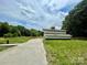 Long driveway leads to a barn, surrounded by lush greenery and a wooden fence at 117 Autumn Woods Dr, Kings Mountain, NC 28086