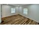 A cozy bedroom with a light color palette, hardwood floors, and natural light from two windows at 117 Autumn Woods Dr, Kings Mountain, NC 28086