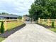 Long driveway with a decorative gate, wood fence, and lush green yard at 117 Autumn Woods Dr, Kings Mountain, NC 28086