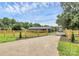 Landscaped home exterior with a fenced yard, gate and driveway surrounded by mature trees at 117 Autumn Woods Dr, Kings Mountain, NC 28086
