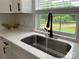 Close-up of a kitchen sink with a modern faucet, white countertops, and a window overlooking a green yard at 117 Autumn Woods Dr, Kings Mountain, NC 28086