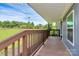 Side porch with a wooden railing, offering a view of the surrounding greenery and nature at 117 Autumn Woods Dr, Kings Mountain, NC 28086