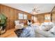Well-lit living room with hardwood floors, wood paneling, and a comfortable seating area at 1188 Rainbow Cir, Catawba, SC 29704