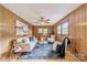 Cozy living room with hardwood floors, wood paneling, fan, and a stylish seating arrangement at 1188 Rainbow Cir, Catawba, SC 29704