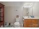 Compact bathroom featuring a toilet, vanity, mirror, and storage cabinet at 119 Ashwood Ln, Mooresville, NC 28117
