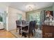 Cozy dining area with wood floors, complemented by green accent wall, rustic furniture, and large sunlit window at 119 Ashwood Ln, Mooresville, NC 28117