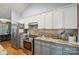 Bright kitchen featuring granite countertops, stainless steel appliances, two-tone cabinets, modern fixtures, and natural light at 119 Ashwood Ln, Mooresville, NC 28117