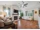 Bright living room boasts vaulted ceilings, brick fireplace, ceiling fan, wood flooring and comfortable seating at 119 Ashwood Ln, Mooresville, NC 28117