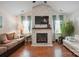 Bright living room features vaulted ceilings, brick fireplace, ceiling fan, wood flooring and comfortable seating at 119 Ashwood Ln, Mooresville, NC 28117