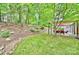 Landscaped backyard with a stone-lined creek, lush lawn, and a cozy pergola-covered patio at 1230 Somersby Ln, Matthews, NC 28105