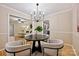 Open-concept dining area with modern lighting and stylish chairs, flowing into the living room and kitchen at 1230 Somersby Ln, Matthews, NC 28105
