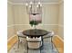Bright dining area with a modern chandelier, round table and stylish chairs on a patterned rug at 1230 Somersby Ln, Matthews, NC 28105