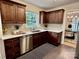 A modern kitchen with stainless steel appliances, white countertops, and dark wood cabinets provides ample space at 1230 Somersby Ln, Matthews, NC 28105