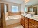 Bright bathroom features a soaking tub with tile surround and double sink vanity at 12904 Windy Lea Ln, Huntersville, NC 28078