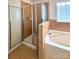 Bathroom featuring a separate shower stall and soaking tub with tile accents at 12904 Windy Lea Ln, Huntersville, NC 28078