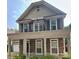 Two-story home showcasing a stone facade, second-story balcony, covered porch, and manicured greenery at 12904 Windy Lea Ln, Huntersville, NC 28078