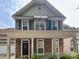 Two-story home with stone accents, front porch, balcony, and well-maintained landscaping at 12904 Windy Lea Ln, Huntersville, NC 28078