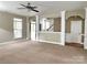 Open-concept living room featuring large windows, neutral carpet, archways, and an inviting atmosphere at 12904 Windy Lea Ln, Huntersville, NC 28078