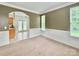 Open-concept living room with bright kitchen view, natural light, wainscoting and ceramic tile flooring at 12904 Windy Lea Ln, Huntersville, NC 28078