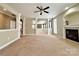 Spacious living room with a fireplace, neutral carpet, archways, and views into other rooms at 12904 Windy Lea Ln, Huntersville, NC 28078