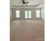 Large main bedroom featuring a tray ceiling, ceiling fan, and access to a private balcony at 12904 Windy Lea Ln, Huntersville, NC 28078