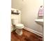 Powder room featuring wood-look flooring, toilet, pedestal sink and wall shelf at 12904 Windy Lea Ln, Huntersville, NC 28078