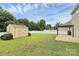 Spacious backyard with a shed, partial view of a patio, and a white vinyl fence at 13407 Morgan Lee Ave, Charlotte, NC 28213