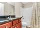 Well-lit bathroom featuring vanity sink and shower/tub with curtain at 13407 Morgan Lee Ave, Charlotte, NC 28213