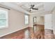 Bright bedroom with hardwood floors, a tray ceiling with fan, and archway access to additional space at 13407 Morgan Lee Ave, Charlotte, NC 28213