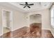Large bedroom with hardwood floors, a tray ceiling with fan, and natural light from the windows at 13407 Morgan Lee Ave, Charlotte, NC 28213