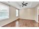 Open bedroom with hardwood floors, tray ceiling with fan and natural light from large windows at 13407 Morgan Lee Ave, Charlotte, NC 28213