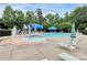 Community pool featuring fountain, water slide, and various colorful umbrellas with lounge chairs at 13407 Morgan Lee Ave, Charlotte, NC 28213