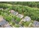 Suburban aerial view of a community with mature trees, lawns, and a golf course in the distance at 13716 Glen Abbey Dr, Charlotte, NC 28278