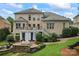 Spacious backyard with a deck, a stone fire pit, and mature landscaping at 13716 Glen Abbey Dr, Charlotte, NC 28278