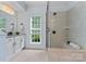 Bright bathroom featuring a glass shower and a granite countertop vanity at 13716 Glen Abbey Dr, Charlotte, NC 28278