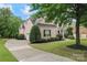 Charming brick home with manicured lawn, mature trees, and a private driveway at 13716 Glen Abbey Dr, Charlotte, NC 28278
