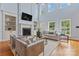 Bright living room featuring a fireplace, tall windows, built-in shelving and hardwood floors at 13716 Glen Abbey Dr, Charlotte, NC 28278