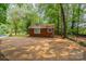 A cozy brick home features a backyard patio and lush green foliage at 1401 Hillwood Ct, Charlotte, NC 28210