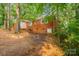 Exterior shot of brick home featuring large trees and a fenced yard at 1401 Hillwood Ct, Charlotte, NC 28210