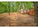 A spacious, private backyard with mature trees and a charming brick home at 1401 Hillwood Ct, Charlotte, NC 28210