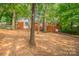 Exterior shot of brick home featuring large trees and a fenced yard at 1401 Hillwood Ct, Charlotte, NC 28210