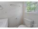 Bathroom featuring a toilet, sink, towel rack, and window at 1401 Hillwood Ct, Charlotte, NC 28210