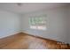 Empty bedroom showcasing hardwood floors and large window at 1401 Hillwood Ct, Charlotte, NC 28210