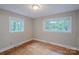 A bedroom with hardwood floors and windows offering bright natural light at 1401 Hillwood Ct, Charlotte, NC 28210
