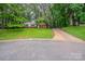 Charming single-story brick home with a well-maintained front yard and lush trees at 1401 Hillwood Ct, Charlotte, NC 28210